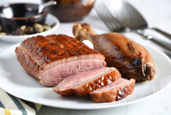 Magret de canard tranché et cuisse dorés sur une assiette