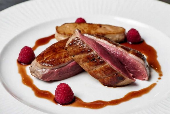 Magret de canard poêlé, foie gras poché et réduction au vinaigre de framboise