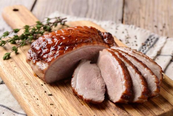 Magret de canard doré et tranché sur une planche à découper