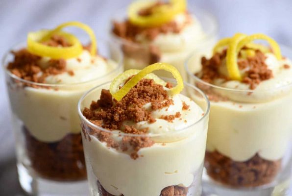 Quatre verres de mousse au citron et spéculoos surmontés de zeste de citron