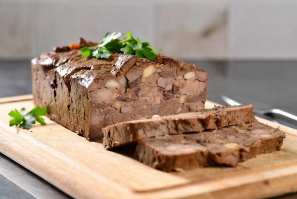 Terrine de foie de volaille tranchée sur une planche à découper
