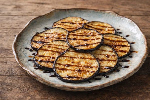 Assiette de berenjenas con miel, le miel fait des traits sur les aubergines