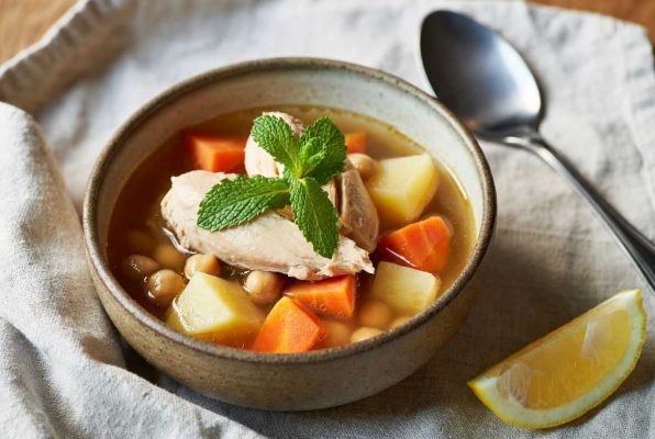 Bol de puchero de verano avec des feuilles de menthe, à côté, un quart de citron
